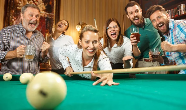 Jeunes hommes et femmes jouant au billard au bureau après le travail . — Photo