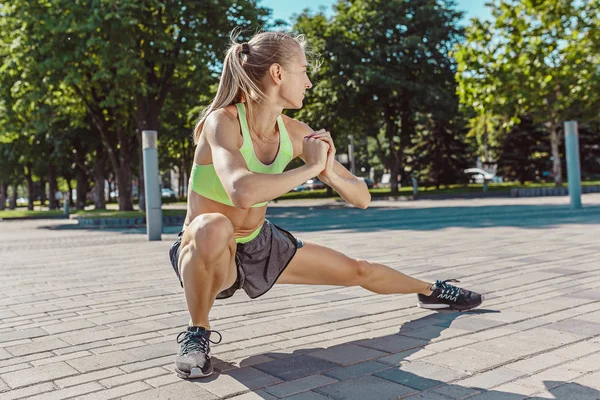 Fit mujer fitness haciendo ejercicios de estiramiento al aire libre en el parque —  Fotos de Stock