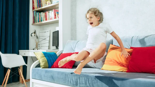 Piccolo sorpreso teen ragazza guardando la tv a casa . — Foto Stock