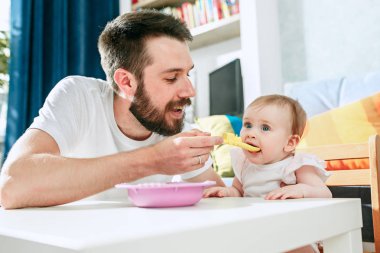 İyi genç adam yemek kahvaltı arıyor ve onu bebek kız evde besleme