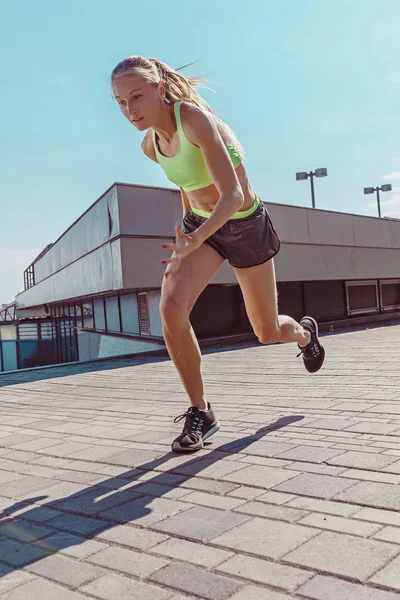 Mulher muito desportiva correndo na cidade — Fotografia de Stock