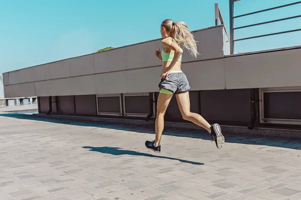 Mujer bastante deportiva trotando en la ciudad — Foto de Stock