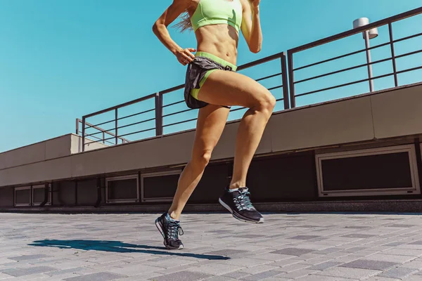 Mulher muito desportiva correndo na cidade — Fotografia de Stock