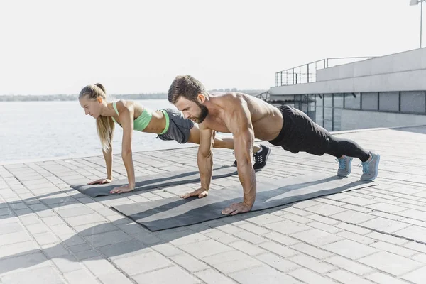 Fit Fitness Frau und Mann bei Fitnessübungen im Freien in der Stadt — Stockfoto