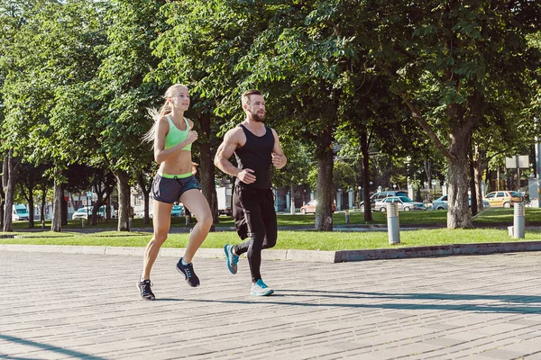 Mujer bastante deportiva y hombre corriendo en la ciudad —  Fotos de Stock