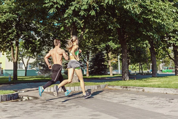 Красива спортивна жінка і чоловік біжить по місту — стокове фото