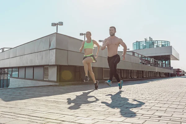 Ganska sportig kvinna och man som jogging på city — Stockfoto