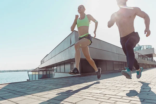 Ganska sportig kvinna och man som jogging på city — Stockfoto