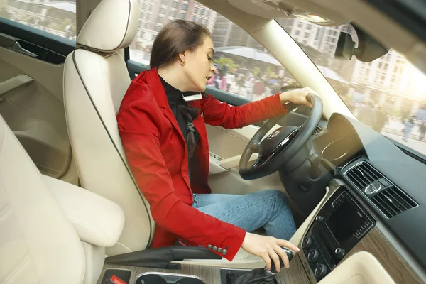 Driving around city. Young attractive woman driving a car