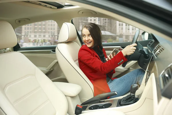 A conduzir pela cidade. Jovem mulher atraente dirigindo um carro — Fotografia de Stock