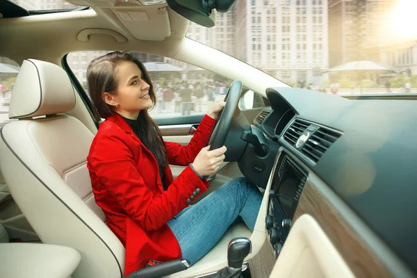 A conduzir pela cidade. Jovem mulher atraente dirigindo um carro — Fotografia de Stock