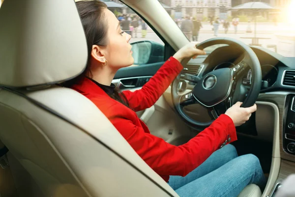 Driving around city. Young attractive woman driving a car