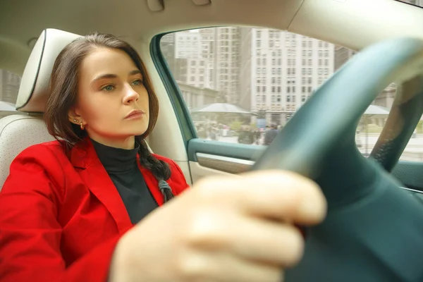 A conduzir pela cidade. Jovem mulher atraente dirigindo um carro — Fotografia de Stock