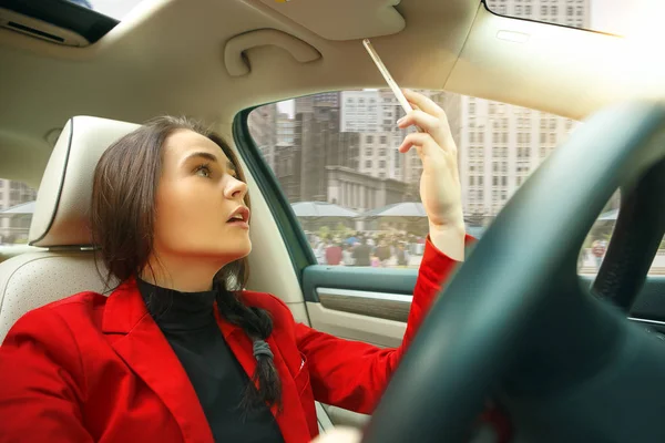 Driving around city. Young attractive woman driving a car