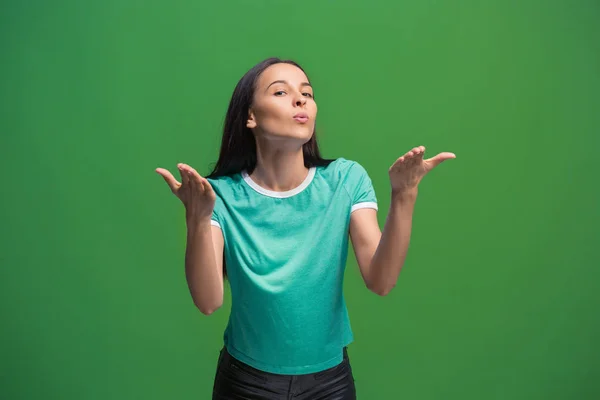 Portret van aantrekkelijke schattig meisje met lichte make-up met kus geïsoleerd op groene achtergrond — Stockfoto