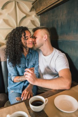 Mutlu genç çift kahve içme ve kafede otururken gülümseyen