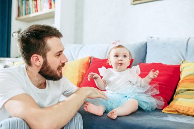 Benim küçük prensesim. Bebek kızı evde tutan genç baba. Çocuk 8 ay-in yaş. Mutlu babalar günü kavramı