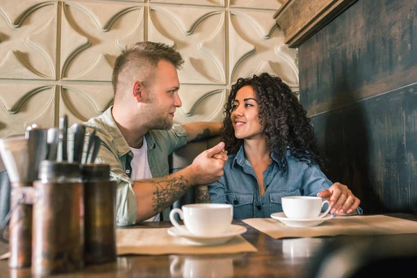 幸せな若いカップルはコーヒーを飲むと、カフェに座って笑顔 — ストック写真