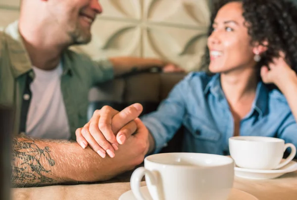 Happy young couple is drinking coffee and smiling while sitting at the cafe — Stock Photo, Image