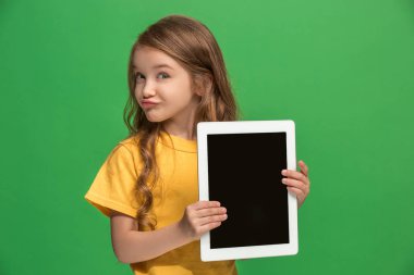 Yeşil zemin üzerine tablet ile küçük kız