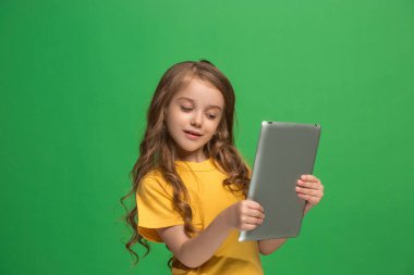 Yeşil zemin üzerine tablet ile küçük kız