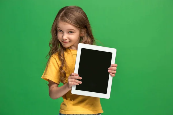 Pequeña chica divertida con la tableta sobre fondo verde —  Fotos de Stock