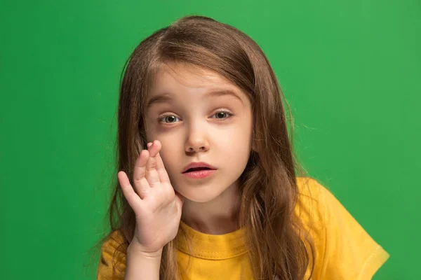 A jovem adolescente sussurrando um segredo atrás de sua mão sobre fundo verde — Fotografia de Stock