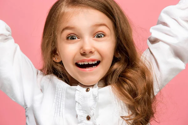 A menina adolescente feliz de pé e sorrindo contra o fundo rosa . — Fotografia de Stock