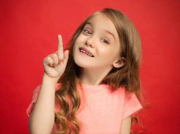 A menina adolescente feliz de pé e sorrindo contra o fundo vermelho . — Fotografia de Stock