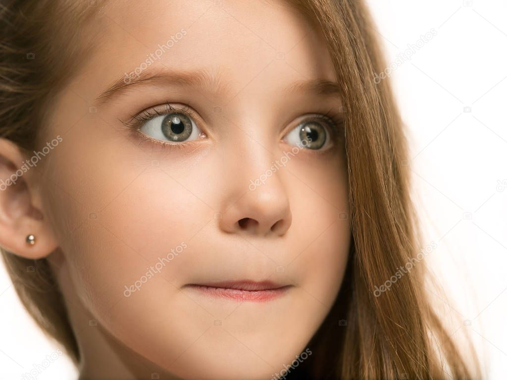 The happy teen girl standing and smiling against white background.