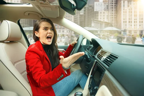 A conduzir pela cidade. Jovem mulher atraente dirigindo um carro — Fotografia de Stock