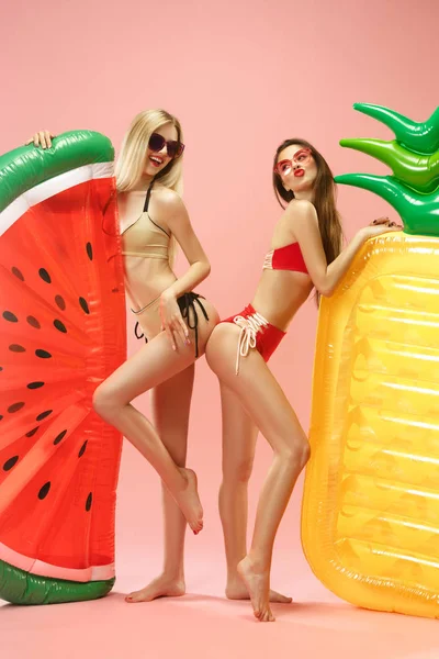 Meninas bonitas em trajes de banho posando no estúdio. Retrato de verão adolescentes caucasianos sobre fundo rosa . — Fotografia de Stock