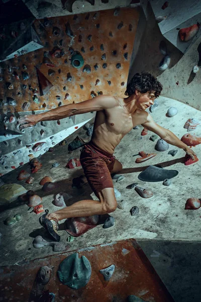 Вільний альпініст молодий чоловік скелелазіння штучний валун в приміщенні — стокове фото