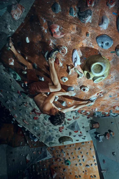 Arrampicante giovane arrampicatore boulder artificiale indoor — Foto Stock