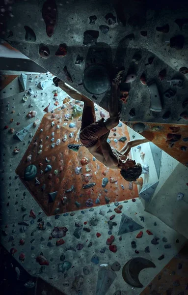 Freikletterer junger Mann klettert künstlichen Boulder drinnen — Stockfoto