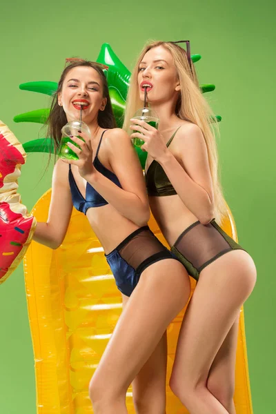 Chicas lindas en trajes de baño posando en el estudio. Retrato de verano caucásico adolescentes sobre fondo verde . — Foto de Stock