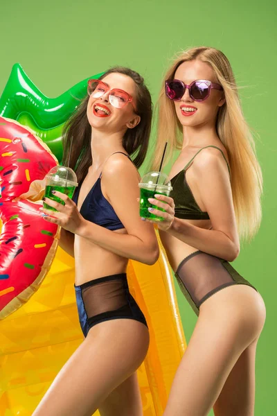 Chicas lindas en trajes de baño posando en el estudio. Retrato de verano caucásico adolescentes sobre fondo verde . — Foto de Stock