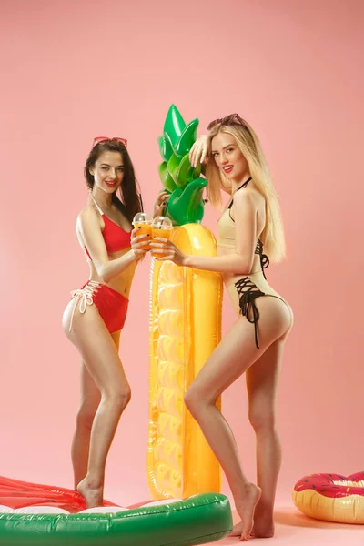 Chicas lindas en trajes de baño posando en el estudio. Retrato de verano caucásico adolescentes sobre fondo rosa . — Foto de Stock