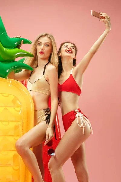 Meninas bonitas em trajes de banho posando no estúdio. Retrato de verão adolescentes caucasianos sobre fundo rosa . — Fotografia de Stock