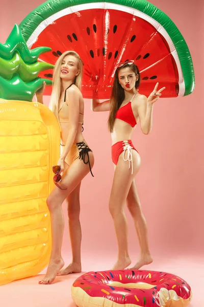 Meninas bonitas em trajes de banho posando no estúdio. Retrato de verão adolescentes caucasianos sobre fundo rosa . — Fotografia de Stock