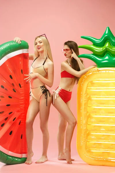 Filles mignonnes en maillots de bain posant au studio. Portrait d'été adolescents caucasiens sur fond rose . — Photo