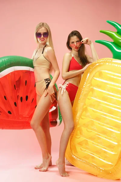 Meninas bonitas em trajes de banho posando no estúdio. Retrato de verão adolescentes caucasianos sobre fundo rosa . — Fotografia de Stock