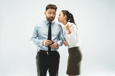 Beyaz arka plan üzerinde elini arkasındaki sır fısıldayan genç kadın