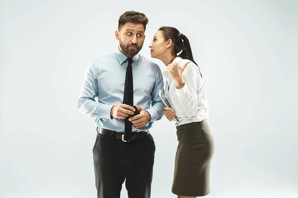 La giovane donna sussurrando un segreto dietro la mano su sfondo bianco — Foto Stock