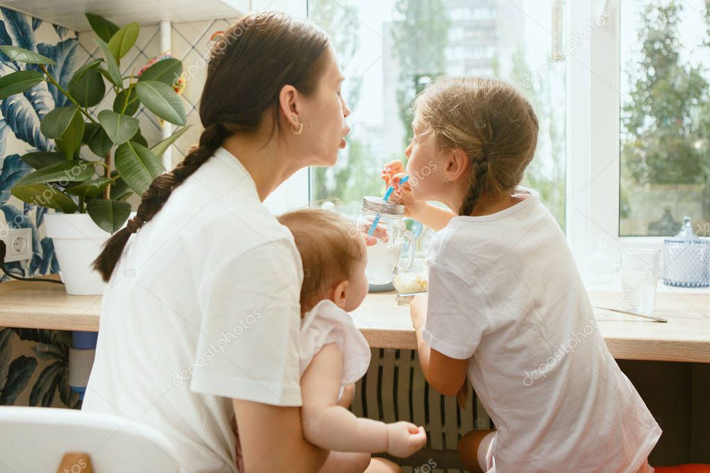 The happy smiling caucasian family in the kitchen preparing breakfast