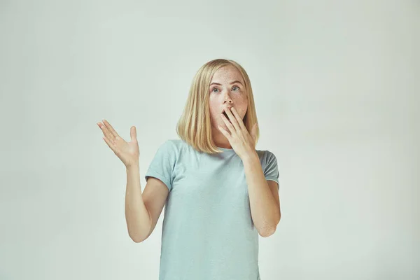 Bella donna sembra sorpreso isolato su grigio — Foto Stock