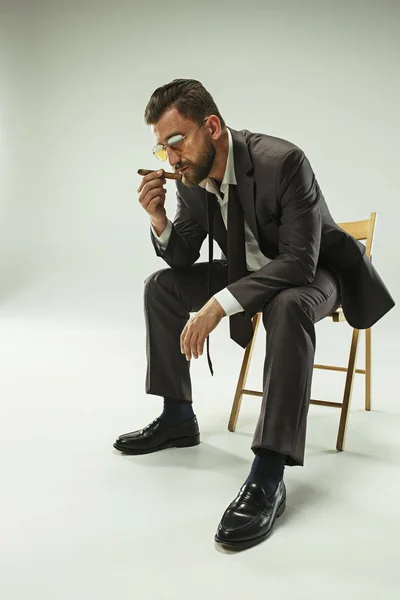 El hombre barbudo con un traje sosteniendo cigarros — Foto de Stock