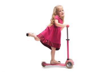 Şirin bebek kız üç yıl beyaz arka plan üzerinde bir scooter sürme gülümseyen
