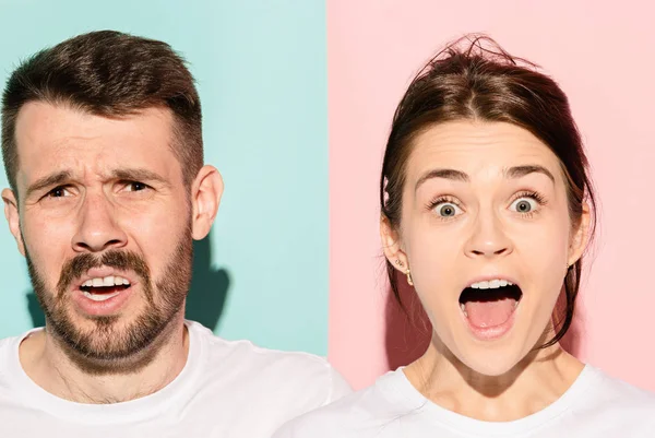 Closeup portrait of young couple, man, woman. One being excited happy smiling, other serious, concerned, unhappy on pink and blue background. Emotion contrasts — Stock Photo, Image