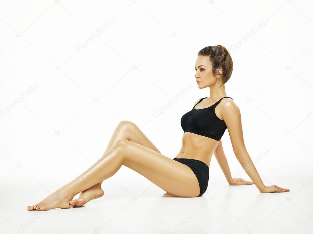 Muscular young woman athlete posing at studio